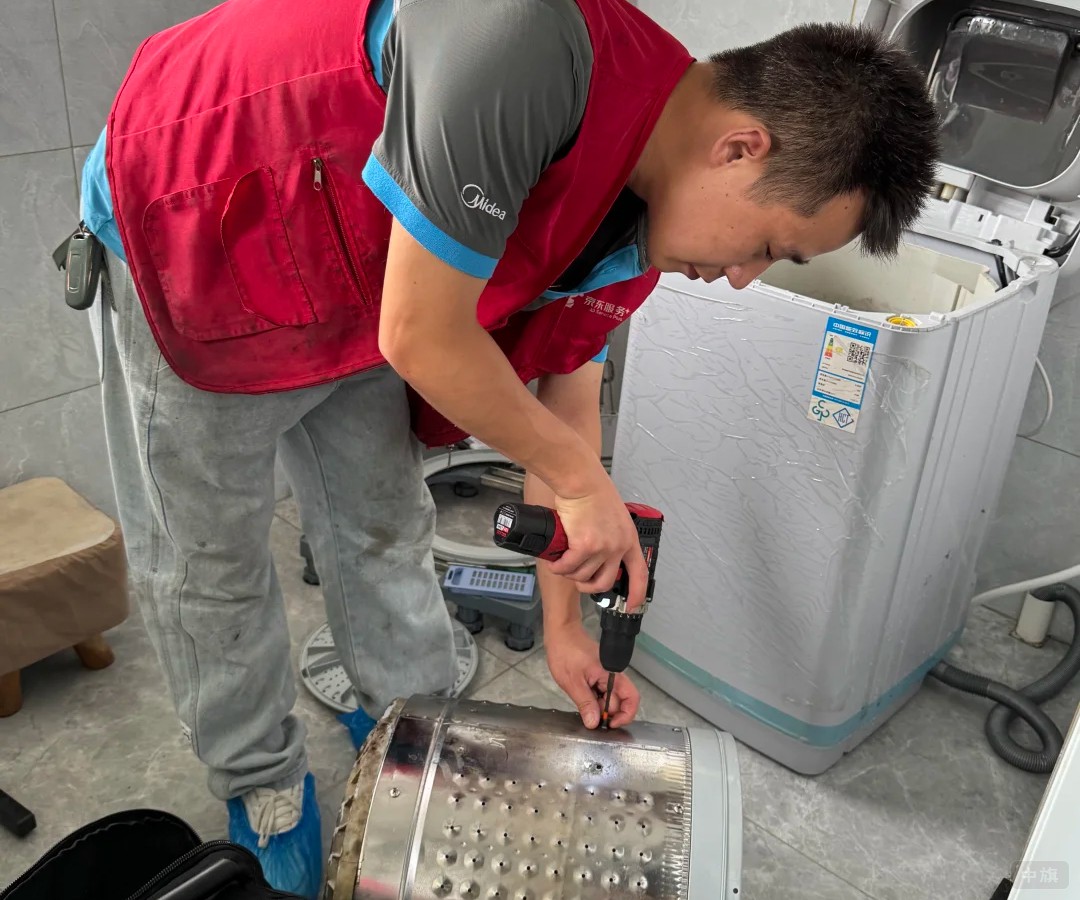 師傅在用電動扳手拆洗衣機(jī)的滾筒